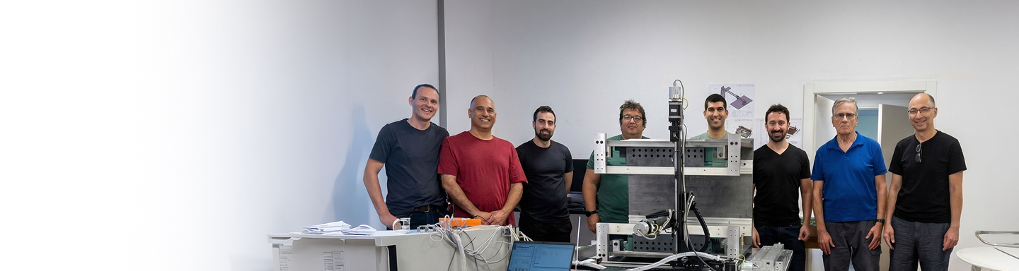 The Agile team in the lab beside an early magnet assembly